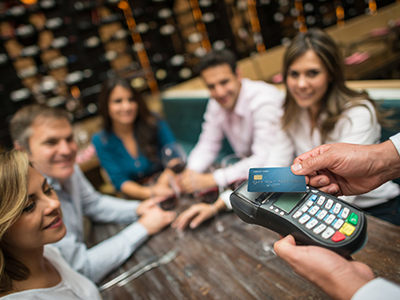 People making a contactless payment at a restaurant with a credit card