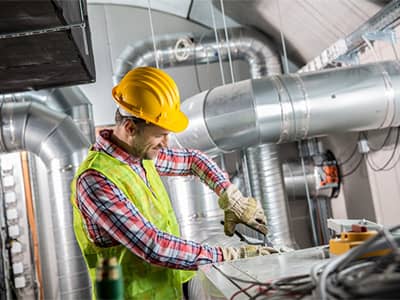 Construction worker installing an HVAC unit.