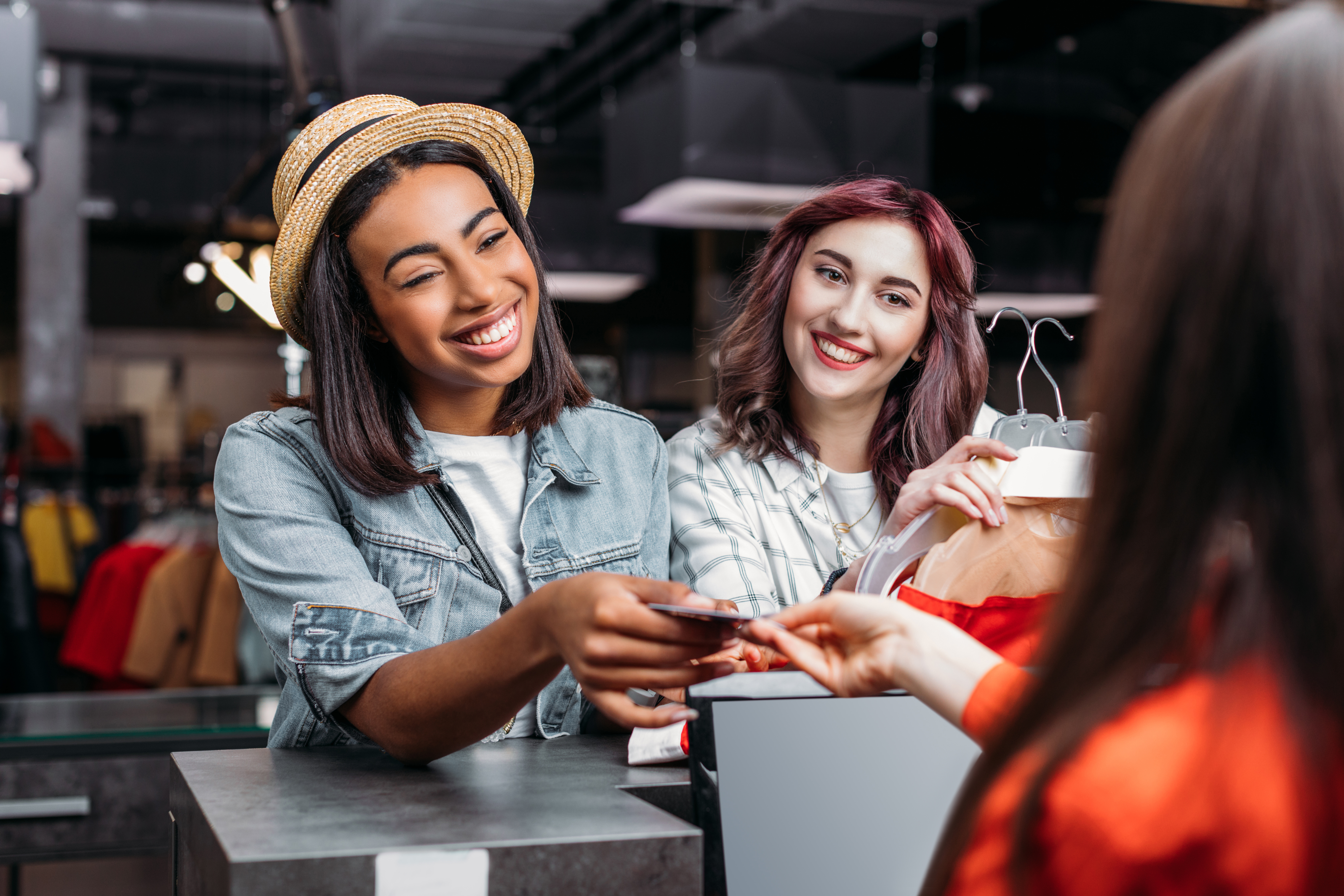 Woman paying for groceries with her debit card: handing card to teller