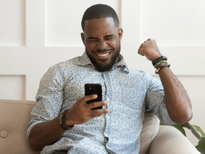 Man-showing-excitement-while-looking-at-phone