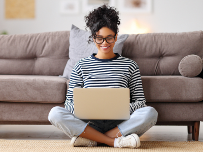 Woman looking happily at laptop (1)